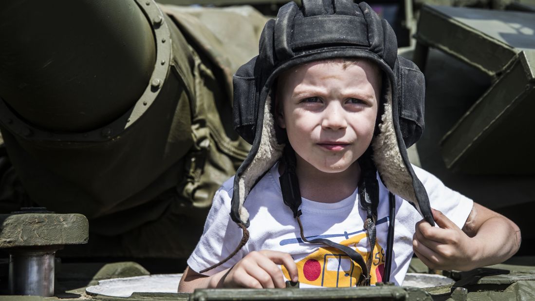  A boy plays on a tank. 