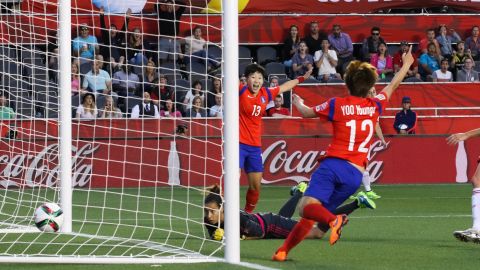 Hahnul Kwon and Younga Yoo celebrate as the ball goes into the net behind Spanish goalkeeper Ainhoa Tirapu.