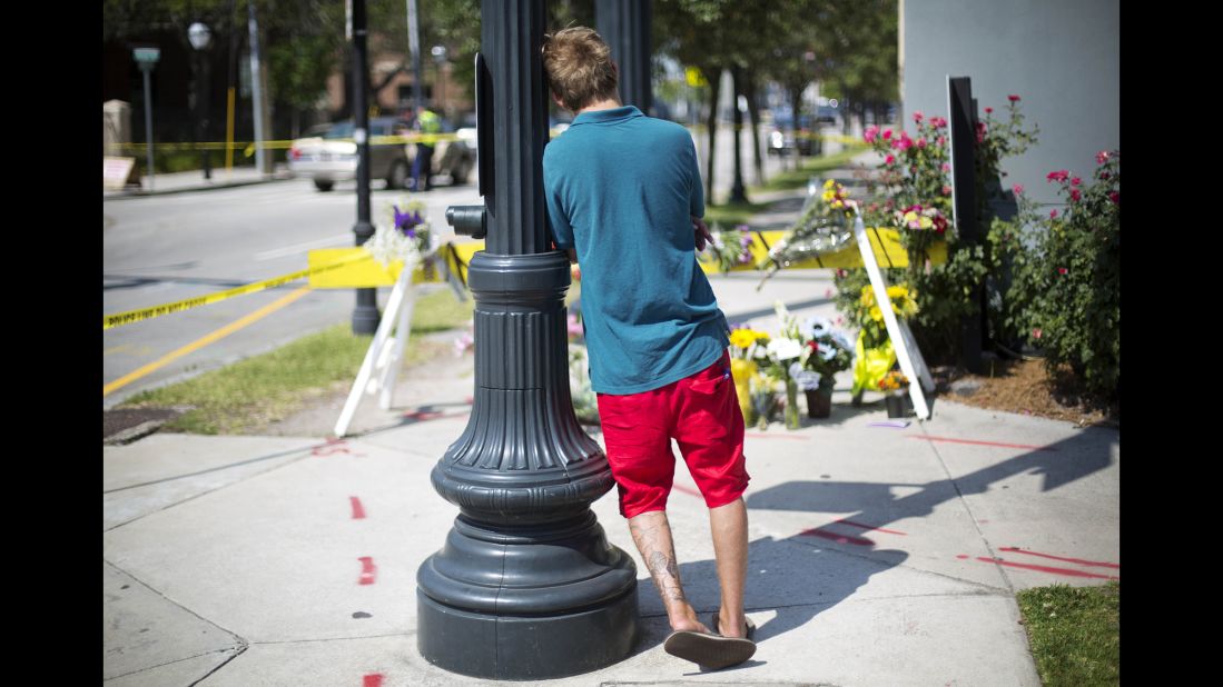 A man leans against a light pole as he visits a memorial in Charleston on June 18.