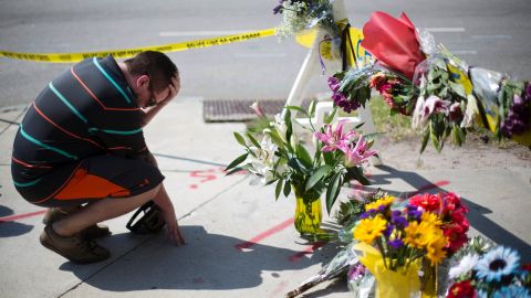 Charleston resident Noah Nicolaisen kneels at a makeshift memorial down the street from the church on June 18.
