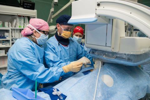 In one of the ship's operating rooms an osteopathic surgeon and obstetrics and gynecology surgeon perform a radiology surgery.