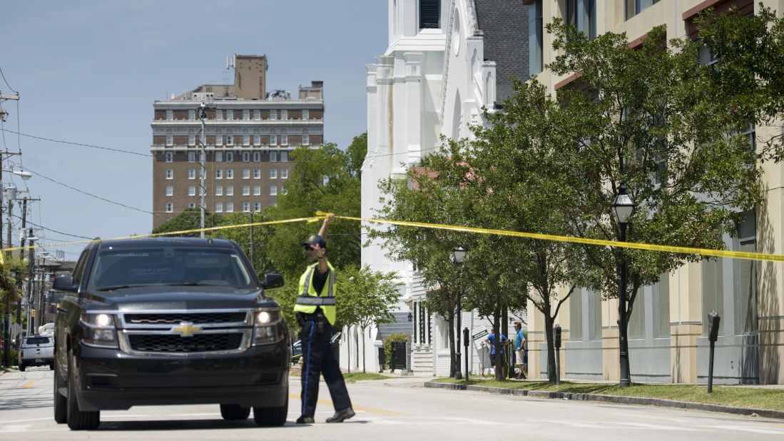 A police officer directs a police vehicle in front of the church on June 18.