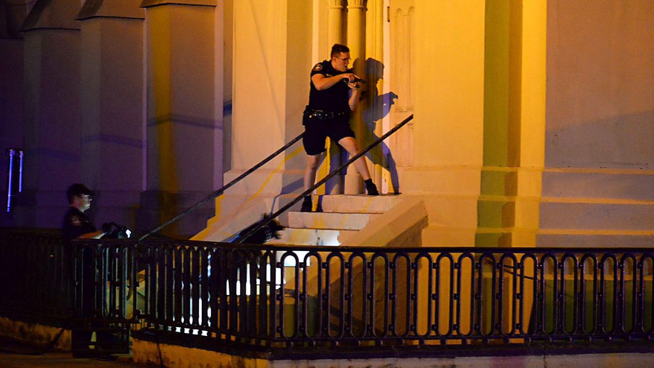 Charleston police officers search for the shooting suspect outside the church on Wednesday, June 17.