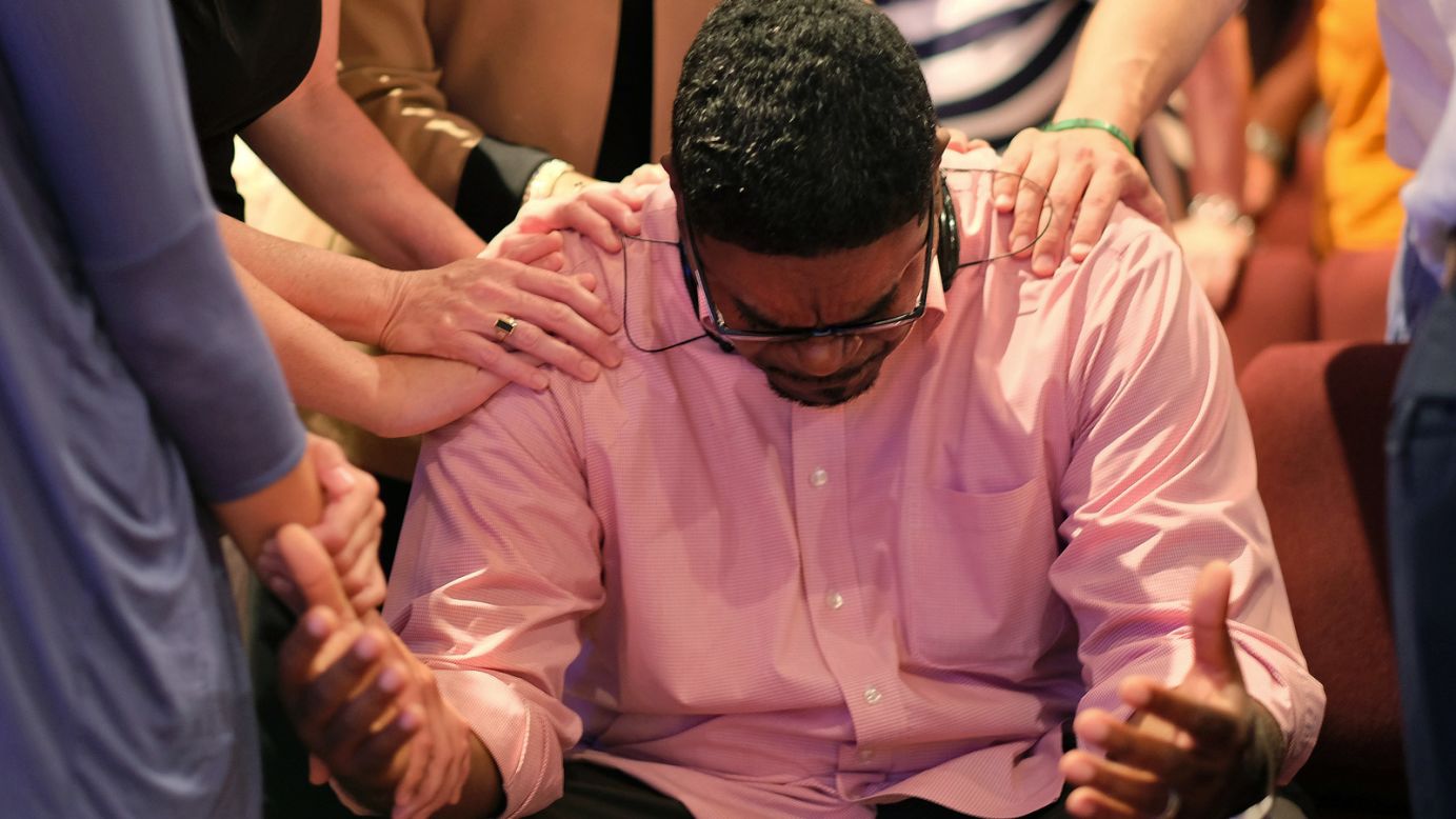 The Rev. Keith McDaniel, pastor of Macedonia Missionary Baptist Church, is surrounded by others in prayer on June 18 in Spartanburg, South Carolina. 