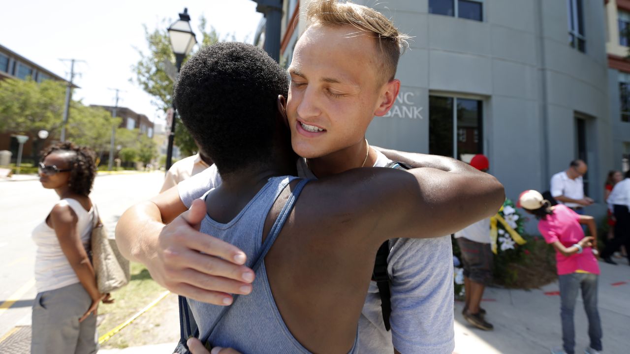 Tyler Francis, right, hugs Shondrey Dear after praying together June 18 at a makeshift memorial near the Emanuel AME Church. 