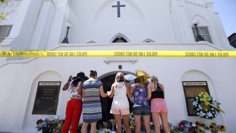 A group of women prays together at a makeshift memorial on the sidewalk in front of the Emanuel AME Church on June 18. 
