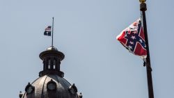 The South Carolina and American flags fly at half mast as the Confederate flag unfurls below at the Confederate Monument June 18, 2015 in Columbia, South Carolina. Legislators gathered Thursday morning to honor their co-worker Clementa Pinckney and the eight others killed Wednesday at Emanuel AME Church in Charleston, South Carolina.