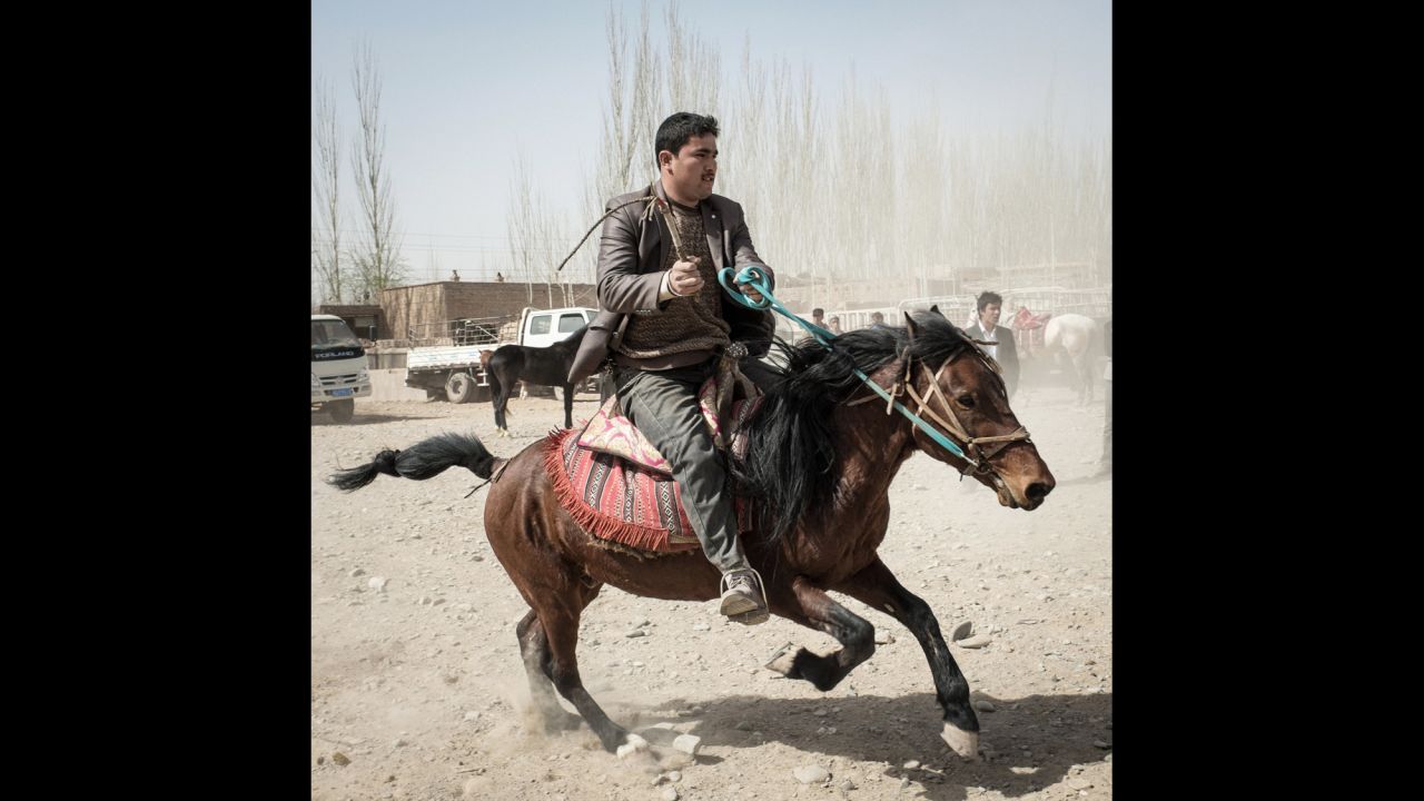 A man rides a horse in a livestock market of the Kashgar area.
