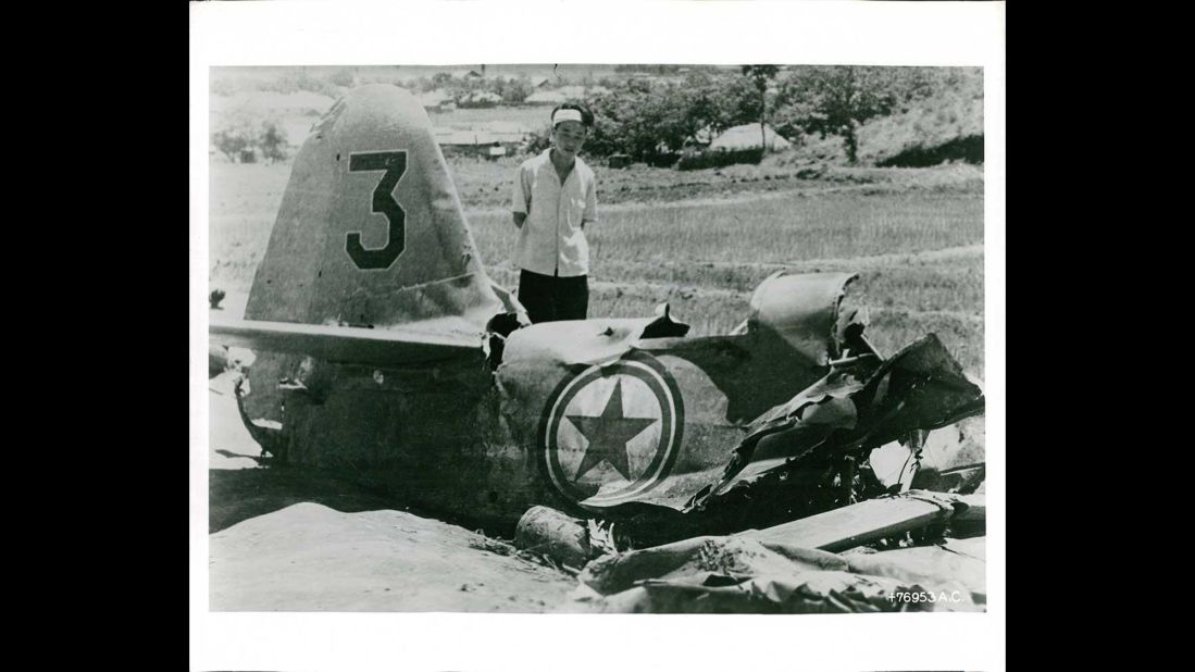 A South Korean inspects wreckage from a downed fighter plane north of Suwon in August 1950. Photo ID: *76953 A.C. 