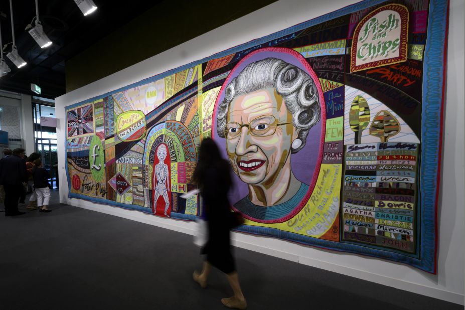 A woman walks in front of an artwork by British artist Grayson Perry entitled 'Comfort Blanket'. 