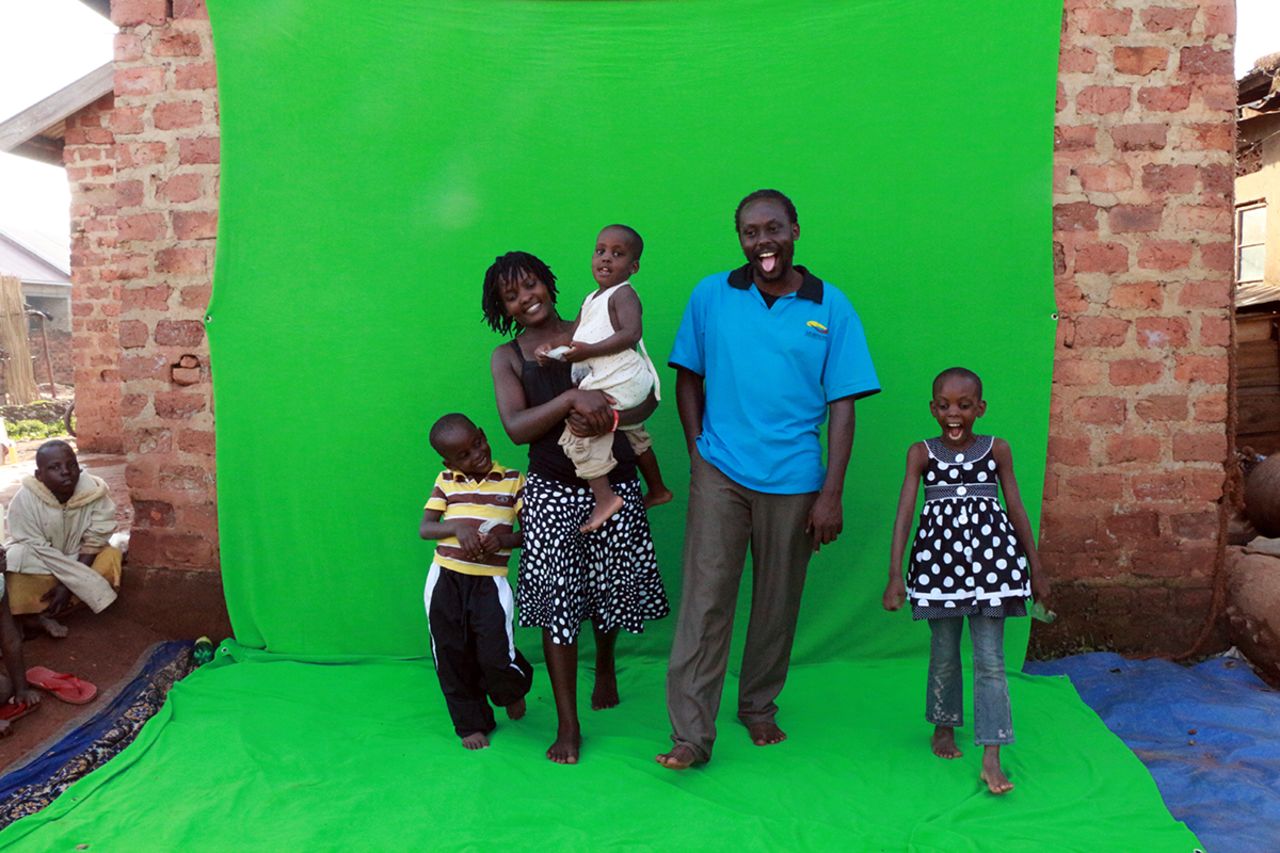 Nabwaana with his wife, Harriet and their three children, stand in front of the makeshift green screen. 'Uganda's motto is: For God and country, and we try and do everything at Wakaliwood for God and country,' says the filmmaker.