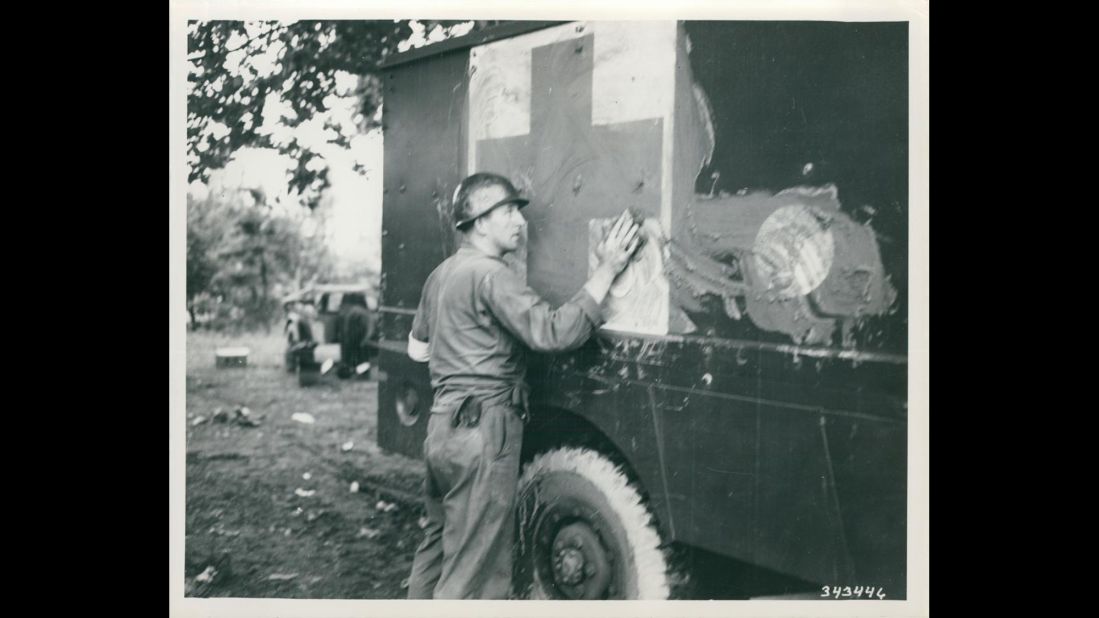 An unidentified medical corpsman of the 24th Medical Battalion tries to camouflage an ambulance with mud in July 1950. Photo ID: SC 343446