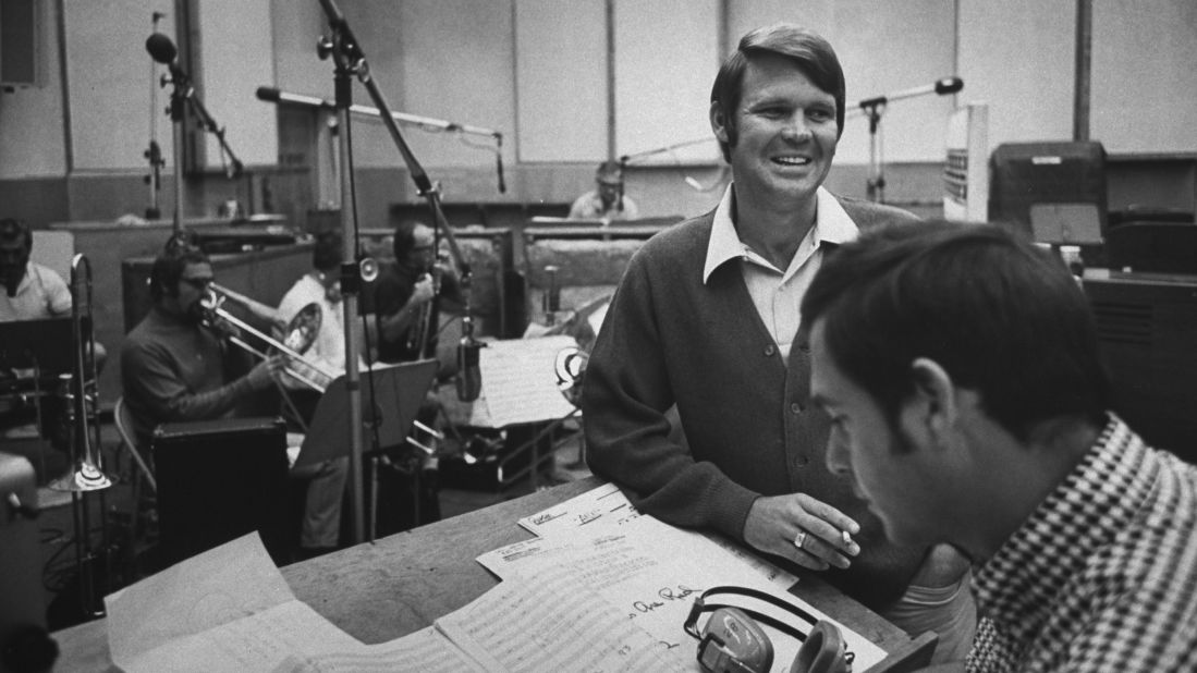 In the early 1960s, Campbell signed with Capitol Records. Here, he is seen at a recording session with producer Al DeLory, who helped Campbell achieve a number of hit singles and albums including "Gentle on My Mind" and "By the Time I Get to Phoenix." 