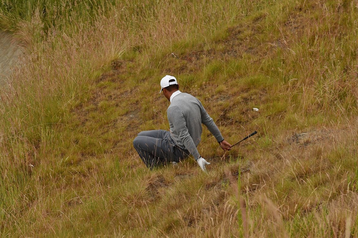 Down and out: Woods slips as he negotiates the rough on the 10th hole on his way to missing the halfway cut at the U.S. Open in June. 