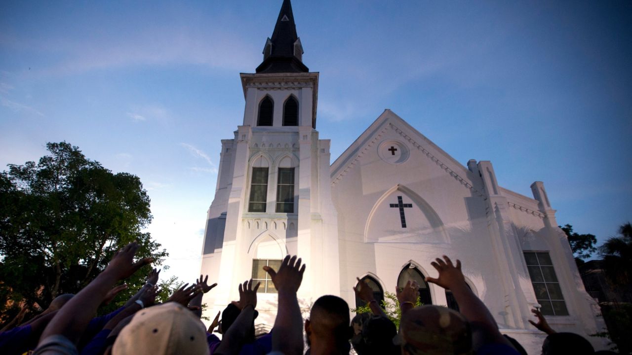 The men of Omega Psi Phi Fraternity Inc. lead a crowd of people in prayer outside the Emanuel AME Church, Friday, June 19, 2015.
