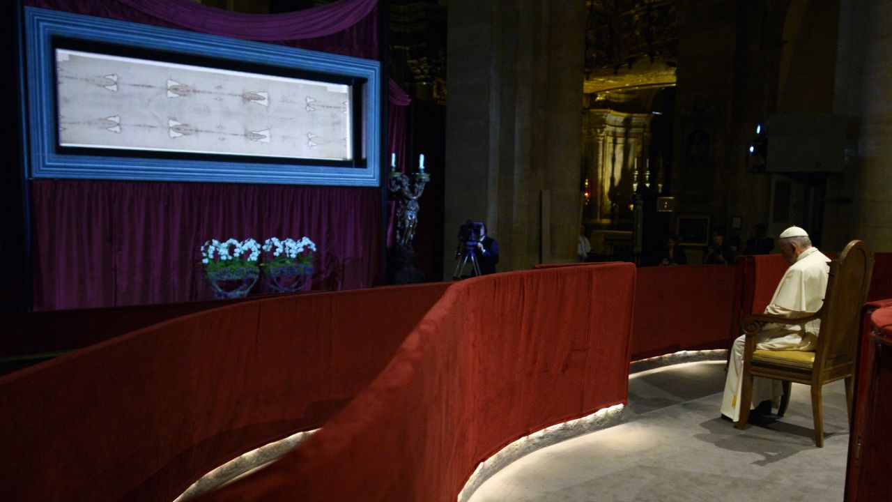 Caption:Pope Francis (R) prays in front of the holy Shroud, believed by some Christians to be the burial shroud of Jesus of Nazareth, on June 21, 2015 in Turin's cathedral. AFP PHOTO / ALBERTO PIZZOLI (Photo credit should read ALBERTO PIZZOLI/AFP/Getty Images)