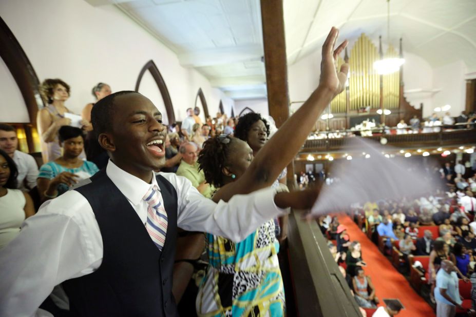 Parishioners Shakur Francis, left, and Karen Watson-Fleming sing as they attend the service. 