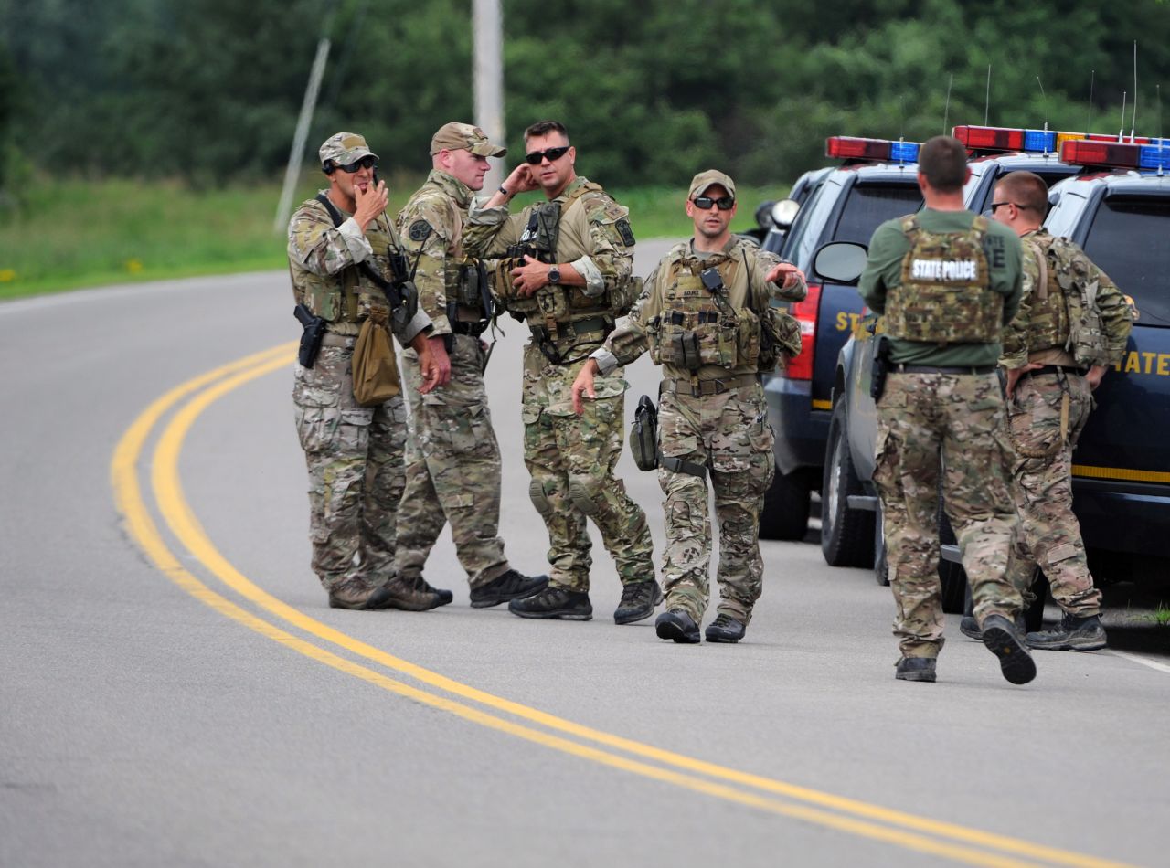 New York State Police officers gather along Route 20 near Friendship on June 21.
