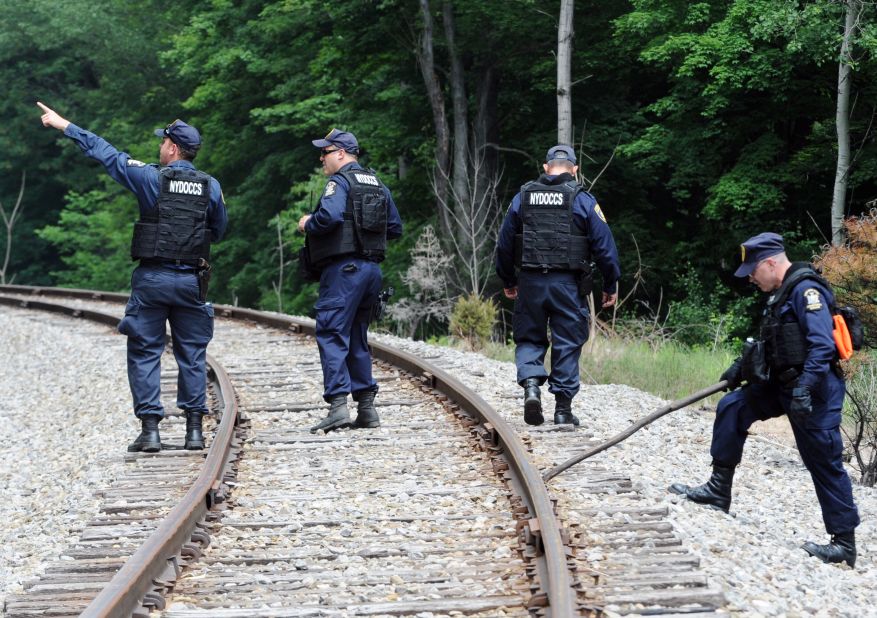 Corrections officers search railroad tracks near Friendship, New York, on Sunday, June 21, after a possible sighting of the fugitives.