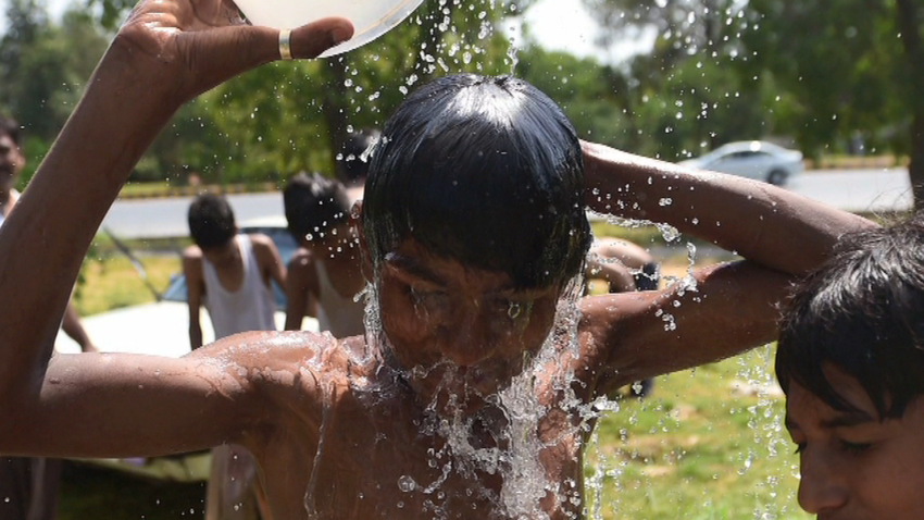 Pakistani youth cool themselves with water during a heat wave in Islamabad on June 21, 2015. At least 17 people have died as a heat wave has gripped the country, local media reported. AFP PHOTO / Farooq NAEEM (Photo credit should read FAROOQ NAEEM/AFP/Getty Images)