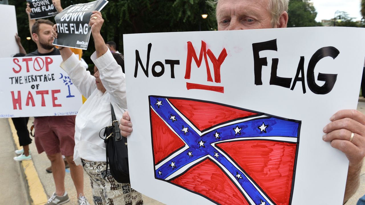 A man holds a sign up during a protest rally against the Confederate flag in Columbia, South Carolina on June 20, 2015. 