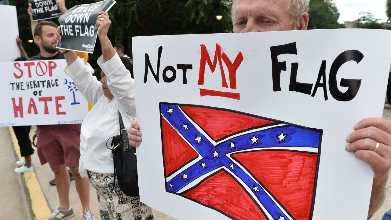 A man holds a sign up during a protest rally against the Confederate flag in Columbia, South Carolina on June 20, 2015.