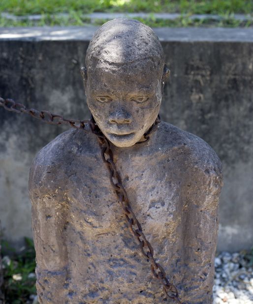 At the slave market, a memorial to those who suffered in crueler times depicts a person in shackles, cuffs and chains attached to a cellar floor.