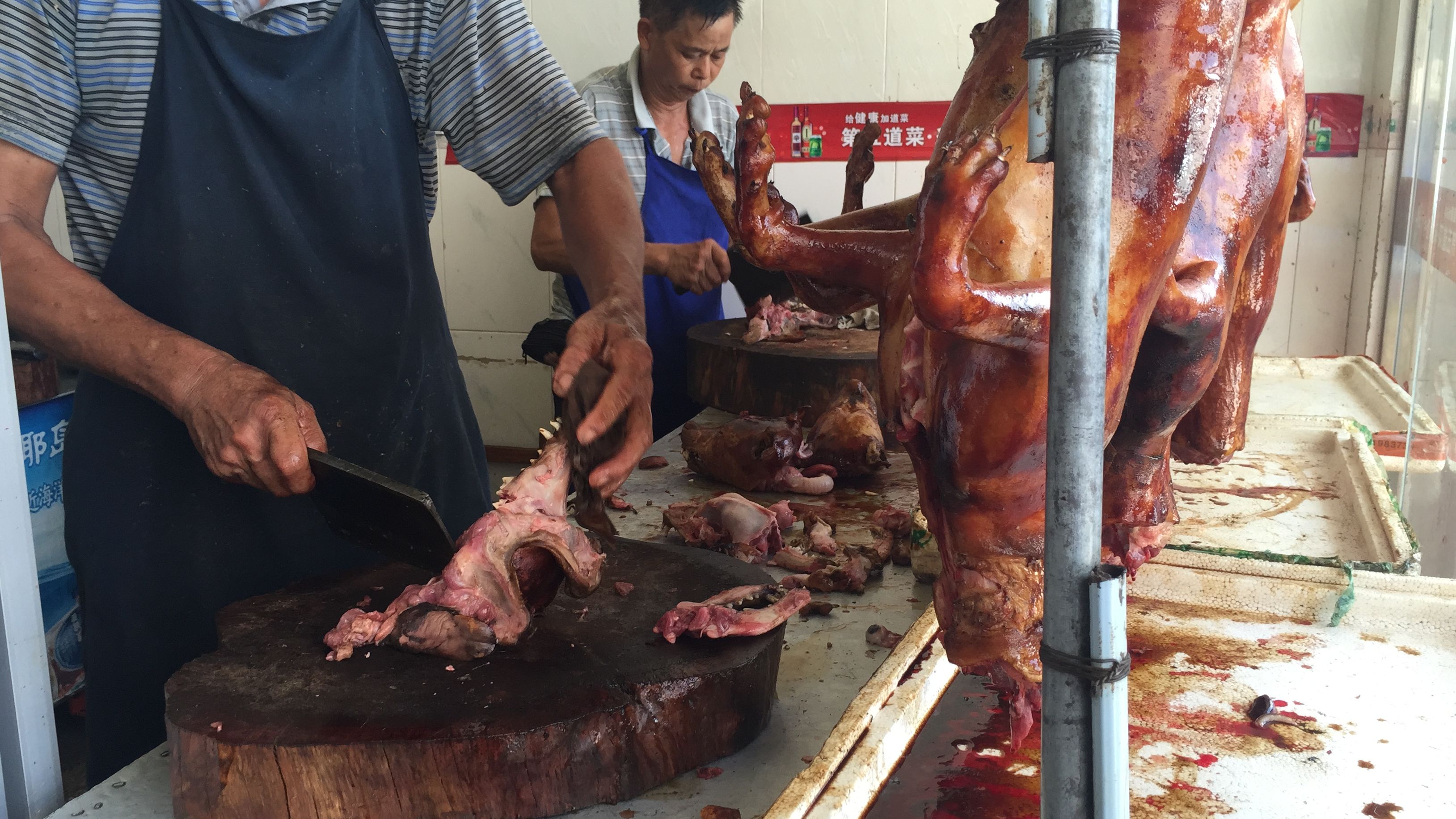 A man chops up dog meat a restaurant in Yulin, Sunday June 21, 2015.
