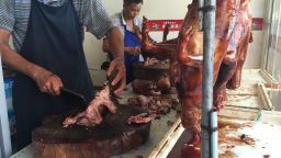 A man chops up dog meat a restaurant in Yulin, Sunday June 21.