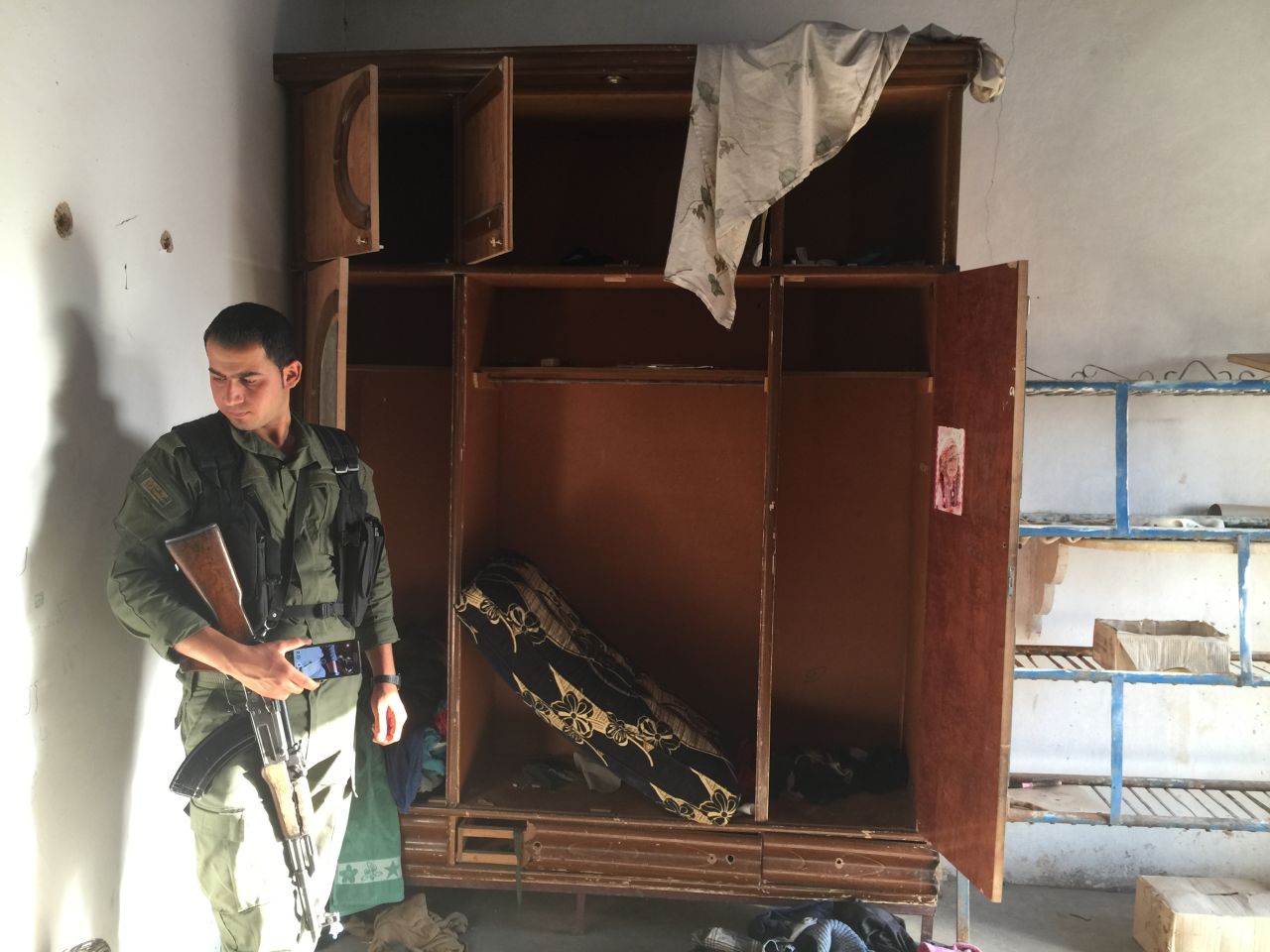 A Kurdish police officer looks around a former ISIS base. 