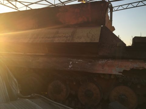 The remains of a bombed-out ISIS armored vehicle, adorned with a verse from the Quran. 