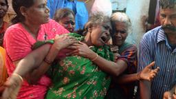 An Indian woman breaks down as she sees the dead body of a family member, a victim of toxic home-made liquor, in Mumbai.