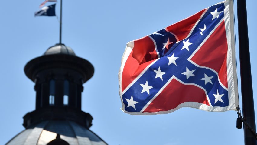 The South Carolina and US flags are seen flying at half-staff behind the Confederate flag erected in front of the State Congress building in Columbia, South Carolina on June 19, 2015. Police captured the white suspect in a gun massacre at one of the oldest black churches in Charleston in the United States, the latest deadly assault to feed simmering racial tensions. Police detained 21-year-old Dylann Roof, shown wearing the flags of defunct white supremacist regimes in pictures taken from social media, after nine churchgoers were shot dead during bible study on Wednesday. AFP PHOTO/MLADEN ANTONOV (Photo credit should read MLADEN ANTONOV/AFP/Getty Images)