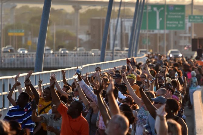 Thousands of people march on the Arthur Ravenel Jr. Bridge in Charleston, South Carolina, on Sunday, June 21.  People crossed the bridge, which spans the Cooper River, from Mount Pleasant to Charleston, joining hands in a unity chain to mourn the Emanuel AME Church shooting. Police arrested Dylann Storm Roof in the slayings of <a href="index.php?page=&url=http%3A%2F%2Fwww.cnn.com%2F2015%2F06%2F18%2Fus%2Fgallery%2Fcharleston-south-carolina-church-shooting%2Findex.html" target="_blank">nine people </a>at a prayer meeting at the church. 