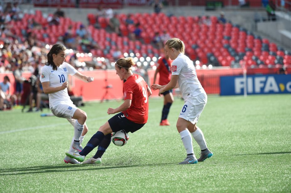 Norway forward Isabell Herlovsen, center, fights for the ball against England's Karen Carney, left. 