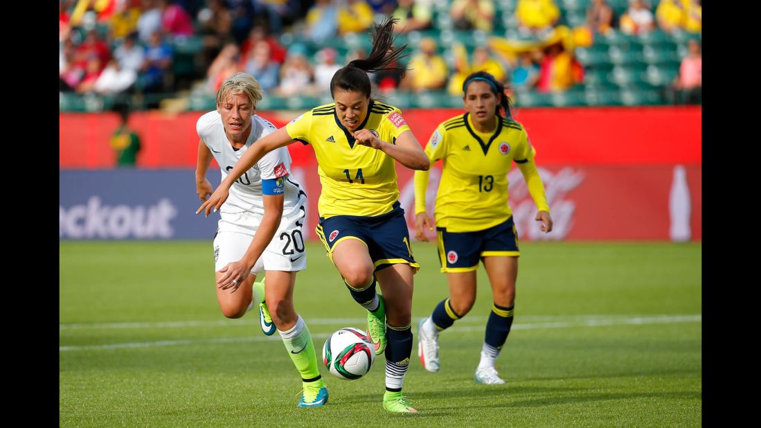 Nataly Arias of Colombia, center, controls the ball near U.S. forward Abby Wambach.