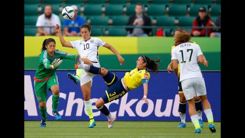 Lloyd goes for the ball between Colombia's Stefany Castano, left, and Natalia Gaitan.