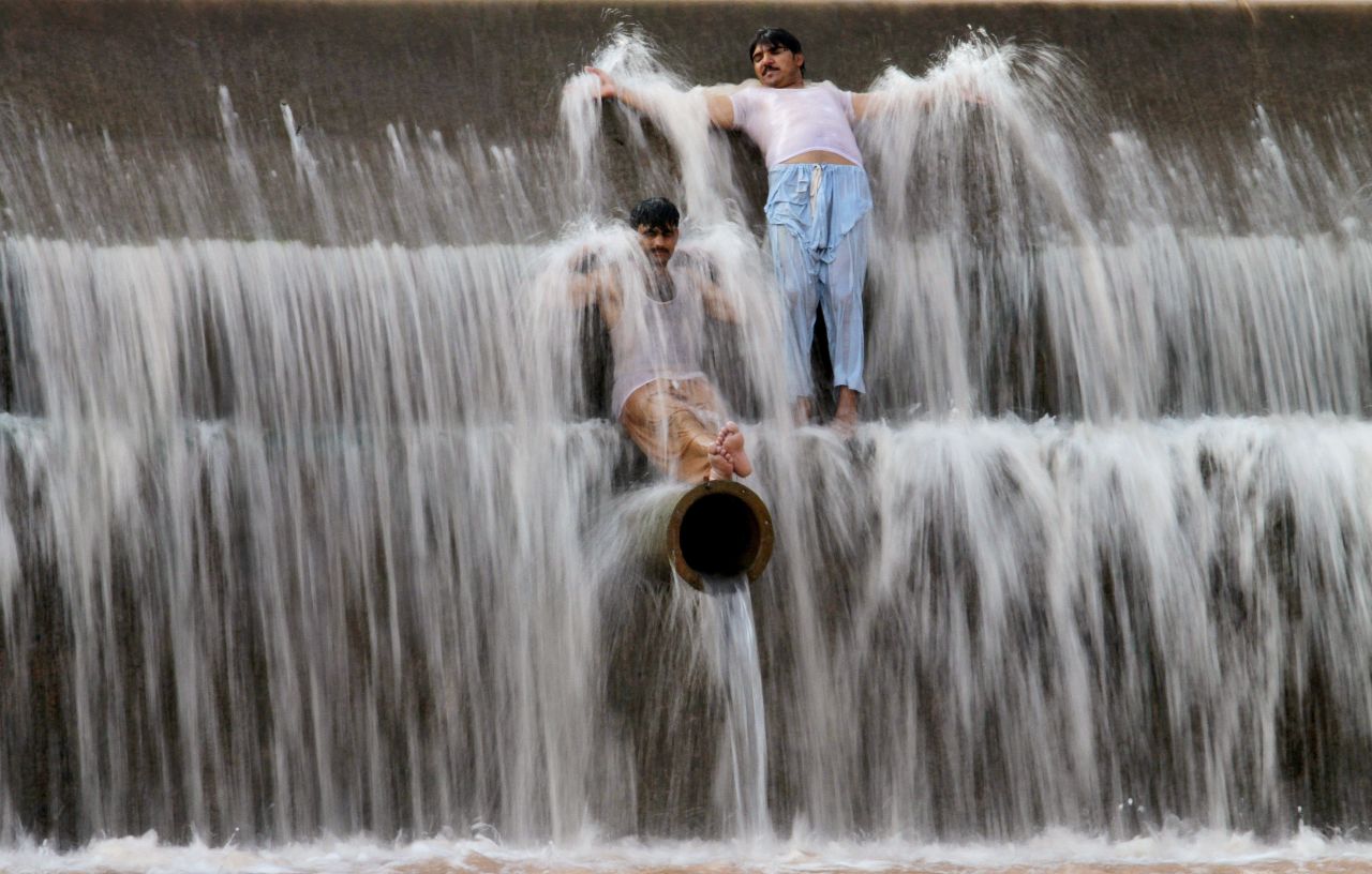 Pakistanis cool off at a river outside Islamabad on Sunday, June 21.