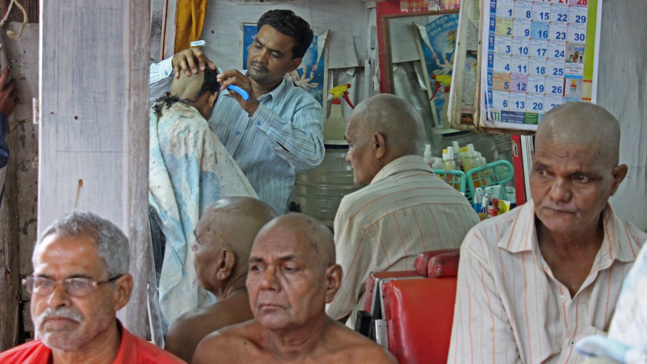 A boy has his head shaved as a sign of mourning for his father.