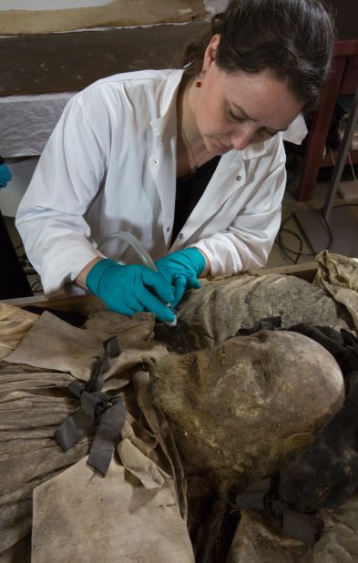 Researchers plan to carry out a DNA test of the fetus found at Winstrup's feet to establish if the two are related. Here museum conservator  Lovisa Dal vacuums the bishop's remains.