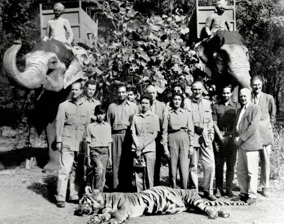 In 1961, Queen Elizabeth II and Prince Philip visited India. Here they are standing with the Maharaja (fourth from the left) and Maharani (fifth from the right) of Jaipur, following a tiger shoot in the Rajasthani city of Jaipur. Despite the fact that she's on a tiger hunt, the Queen has not forgotten her handbag. 