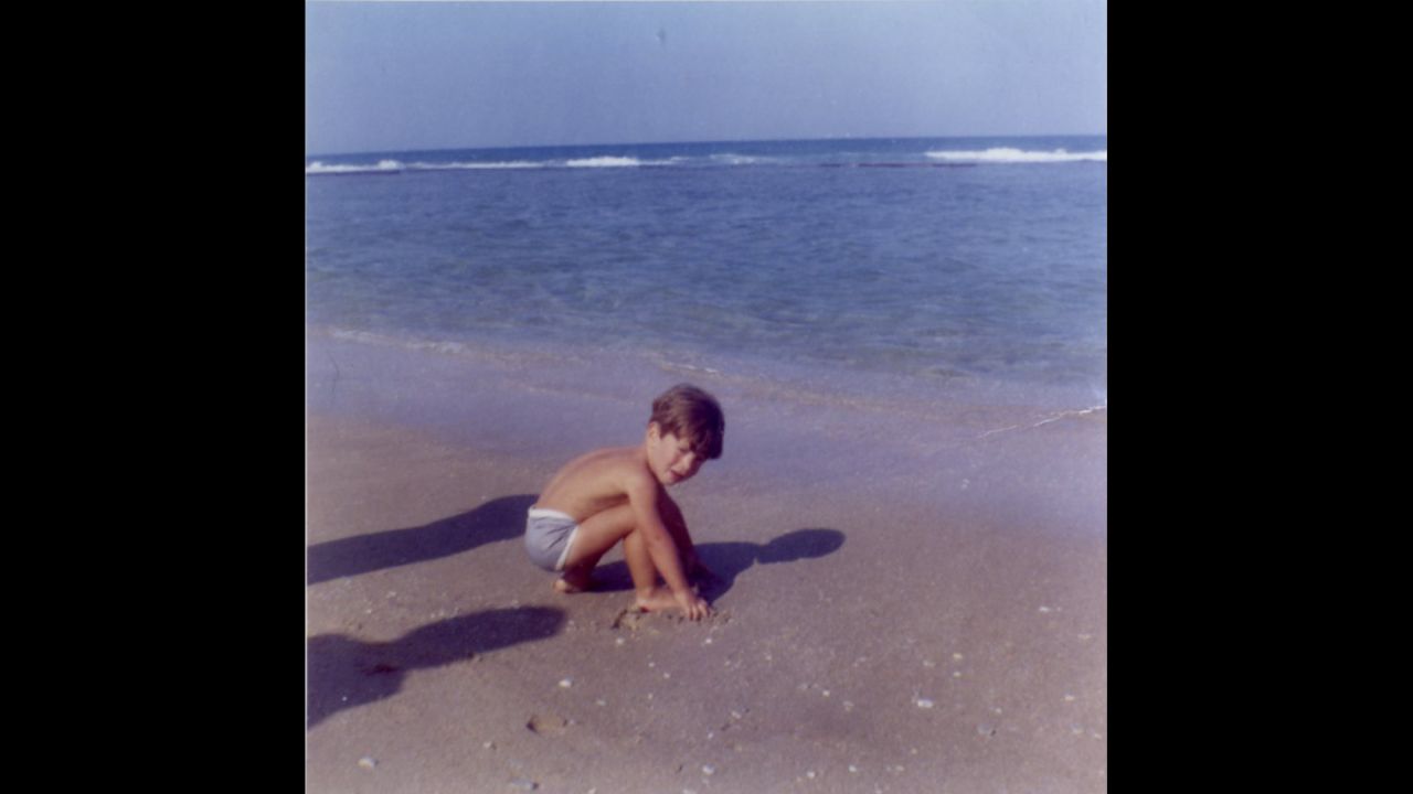 John F. Kennedy Jr. playing in the sand in April 1963.