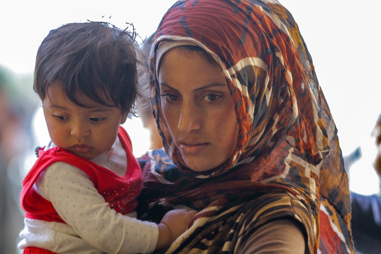 Two Syrian refugees wait for their monthly distribution of food and goods in a photo taken by CNN reporter Michael Robison. The woman pictured above is widowed with two children. She told CNN that her husband was killed in Syria for refusing to join an extremist group. "She is raising her kids and surviving on the support of one particular relief group," Robison said. "She is very kind and very grateful for the aid she gets monthly."