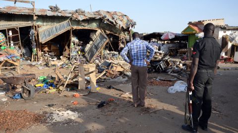 A police officer stands at the scene of a bombing after at least 20 people were killed when a young female suicide bomber detonated her explosives at a bus station in Maiduguri, northeast Nigeria, on June 22, 2015, in an attack likely to be blamed on Boko Haram.
