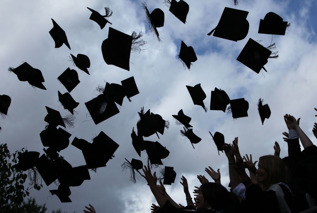 Students throw their caps in the air as they graduate