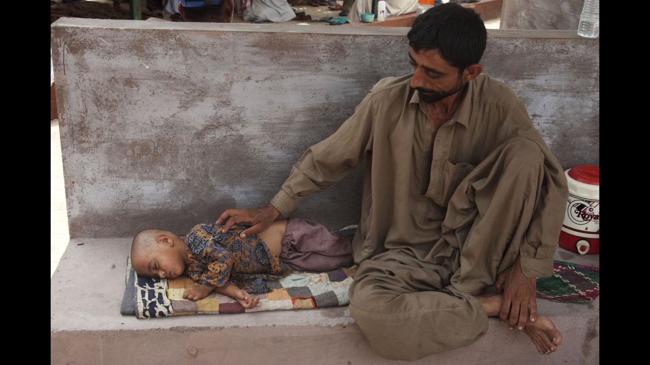 A man awaits medical help for his daughter who is suffering from dehydration due to the extreme weather in Karachi on June 24.