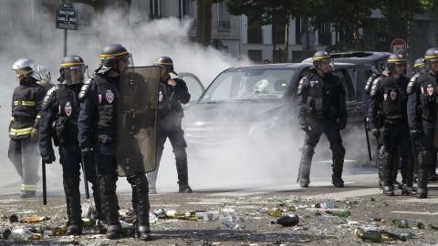 Police stand next to a burned-out car during the Paris protest on June 25.