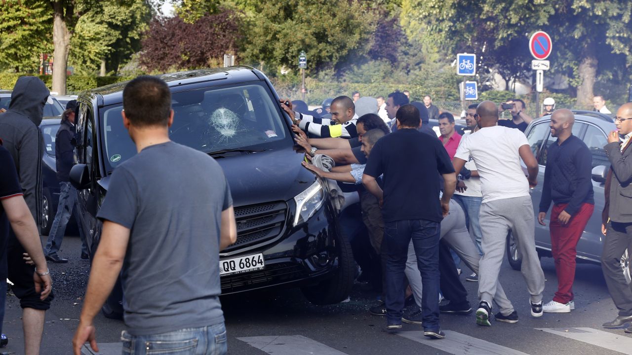 Demonstrators try to turn over a car at Porte Maillot in Paris on June 25.