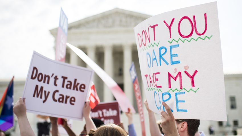 UNITED STATES - JUNE 25: Affordable Care Act supporters hold up signs outside the Supreme Court as they wait for the court's decision on Obamacare on Thursday, June 25, 2015. (Photo By Bill Clark/CQ Roll Call)
