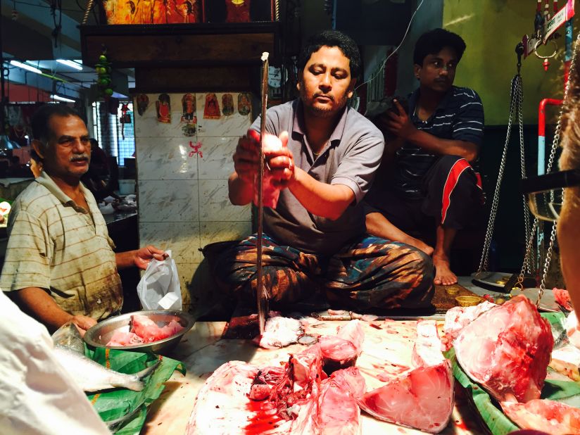A common sight at the Lake Market, a fishmonger slices his catch on a Bengali bonti. The deadly-looking curved blade has been used by the region's fishmongers for centuries.